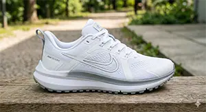 側拍白色網布運動跑鞋，放置在戶外木質長凳上，背景為模糊的綠意公園。